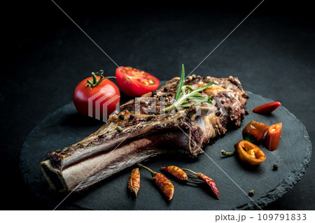Beef steak with rosemary, chili peeper and tomatoes on slate board Beef steak with rosemary, chili peeper and tomatoes on slate board 109791833