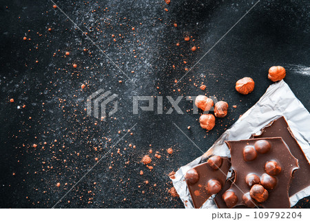 Chocolate and nuts on black table Chocolate and nuts on black table 109792204