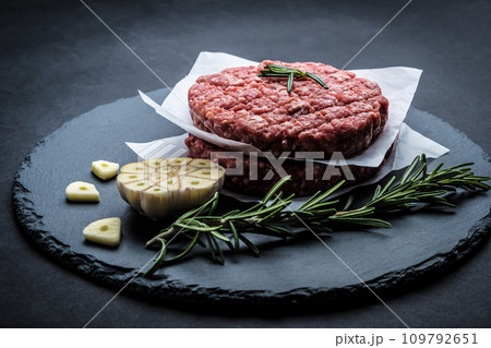 Raw burger beef patty on stone background Raw burger beef patty on stone background 109792651