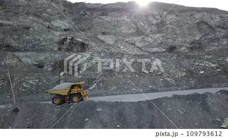 Dump truck loaded with chalk moving on a quarry road. Quarry and mining equipment. 109793612