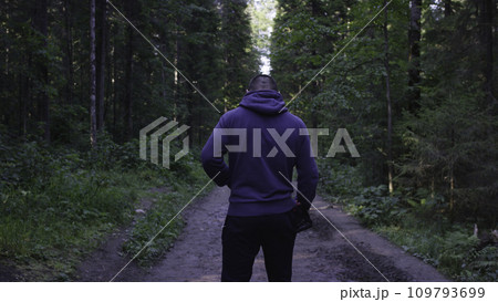 Young man wearing a hat in the woods. Athlete came into the forest to do sports Young man wearing a hat in the woods. Athlete came into the forest to do sports 109793699