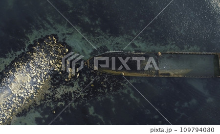 Aerial view of the rusty sunken ship stuck on a rocky shoal. Shot. Old seagoing vessel Aerial view of the rusty sunken ship stuck on a rocky shoal. Shot. Old seagoing vessel 109794080