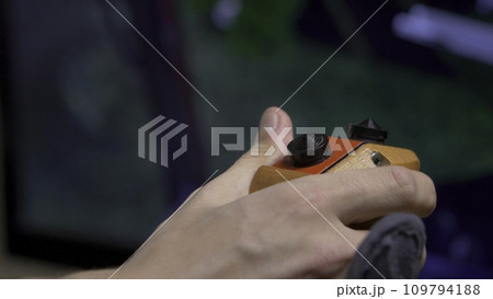Young man plays video game with a retro joystick. Gaming joystick from the mid-1980s. Computer joystick with hand 109794188