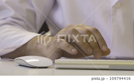 Hands typing on the keyboard. Male hands or man office worker typing on the keyboard 109794416