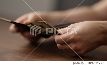 closeup man counting money in brown leather wallet 109794772