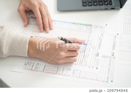 確定申告書類を準備する男性の手元 109794848