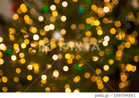 golden bokeh on christmas green background. christmas tree lights. Blurred golden garland on Christmas tree, defocused background. Christmas abstract. golden bokeh on christmas green background. christmas tree lights. Blurred golden garland on Christmas tree, defocused background. Christmas abstract. 109794861