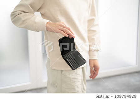 空の財布を持つ若い男性の手元 109794929