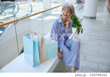 Smiling senior woman relaxing after shopping speaking by phone 109796262