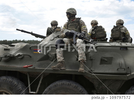 Flag of Artsakh and also known as Nagorno-Karabakh Republic on an armored personnel carrier and soldiers with machine guns. Collage. 109797572