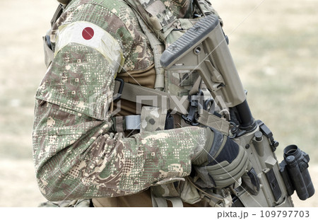 Soldier with assault rifle and flag of Japan on military uniform. Collage. Soldier with assault rifle and flag of Japan on military uniform. Collage. 109797703