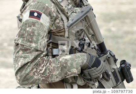 Soldier with assault rifle and flag of Laos on military uniform. Collage. Soldier with assault rifle and flag of Laos on military uniform. Collage. 109797730