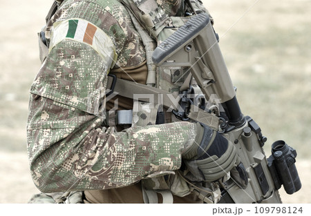 Soldier with assault rifle and flag of Ireland on military uniform. Collage. 109798124
