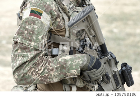 Soldier with assault rifle and flag of Lithuania on military uniform. Collage. Soldier with assault rifle and flag of Lithuania on military uniform. Collage. 109798186