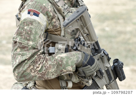 Soldier with assault rifle and flag of Serbia on military uniform. Collage. Soldier with assault rifle and flag of Serbia on military uniform. Collage. 109798207