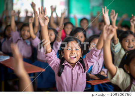 children are raising their hands in a classroom 109800760