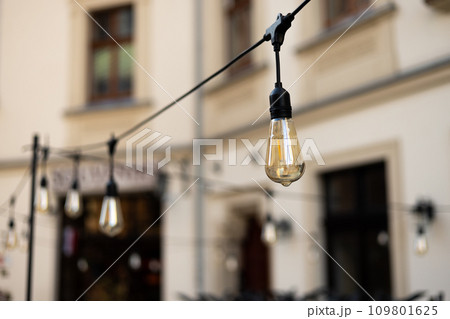 Decorative Outdoor Street electric garland. Old light bulbs. One row of street lights for lighting 109801625