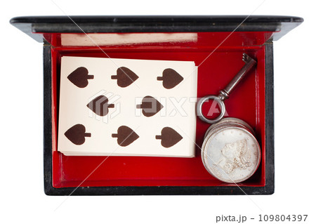 vintage old black and red casket with vintage playing cards and silver dollar coins 109804397