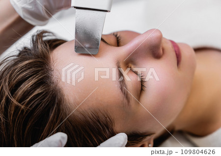 Ultrasonic cleaning of the face. Skin peeling. 109804626