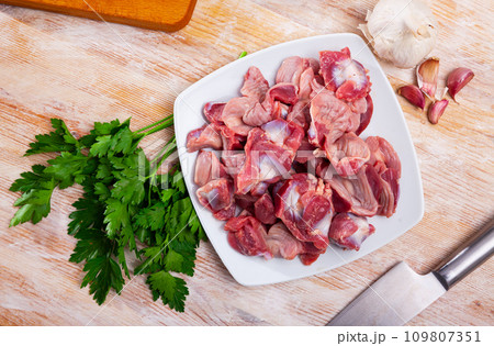 Raw chicken gizzards on wooden table 109807351