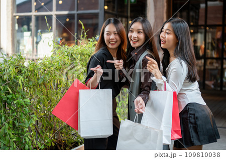 Young happy and attractive three Asian girls are enjoying shopping on the weekend together. 109810038