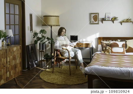 自宅のデスク前に座って書類を見る若い女性のポートレート 自宅のデスク前に座って書類を見る若い女性のポートレート 109810924