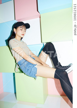 カラフルな背景で撮影をした若い女性のカジュアルなポートレート 109812321