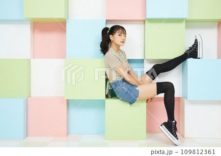 カラフルな背景で撮影をした若い女性のカジュアルなポートレート 109812361