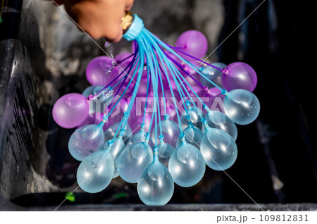 Rapid filling self sealing water balloons being inflated with a hose. Rapid filling self sealing water balloons being inflated with a hose. 109812831