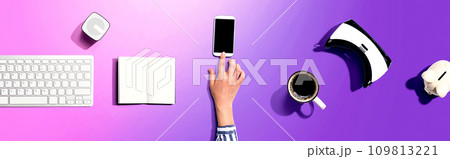 Person using a smartphone with other digital devices 109813221