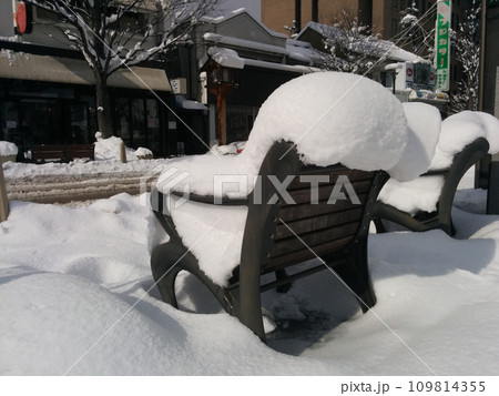 大雪の市街地～雪に埋もれるベンチ 109814355