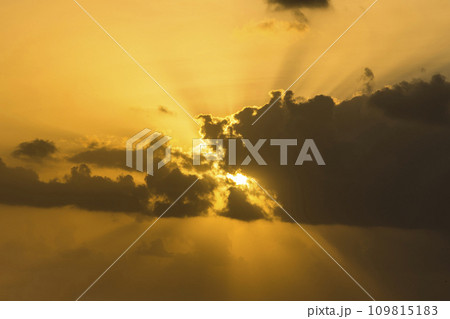 The rays of the rising sun shine through the clouds at sunrise, The sky is covered with dramatic clouds. The rays of the rising sun shine through the clouds at sunrise, The sky is covered with dramatic clouds. 109815183