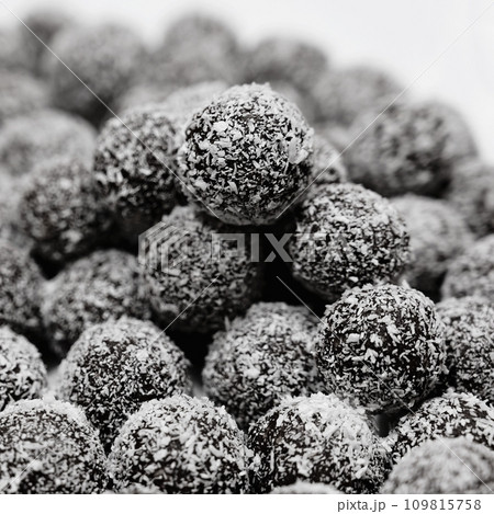 Rum balls in coconut. Traditional unbaked Czech sweets for Christmas and winter. Raw sweet food with cocoa and coconut. Rum balls in coconut. Traditional unbaked Czech sweets for Christmas and winter. Raw sweet food with cocoa and coconut. 109815758