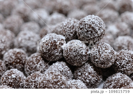 Rum balls in coconut. Traditional unbaked Czech sweets for Christmas and winter. Raw sweet food with cocoa and coconut. 109815759