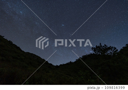 Night sky full of stars and tail of milky way from the top of Doi Luang Chiang Dao in Chiang Mai, Thailand with silhouette of mountains top in the foreground 109816399
