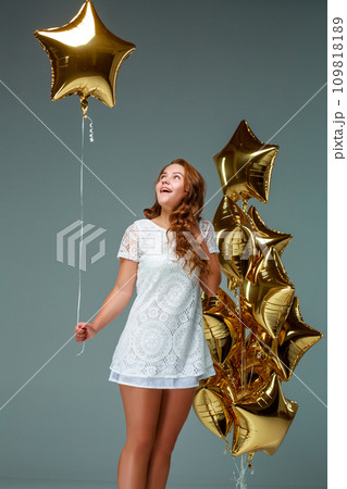 Portrait young attractive woman in white dress, holding bunch of Portrait young attractive woman in white dress, holding bunch of 109818189