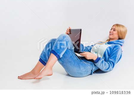 girl in pajamas with a laptop lying on the floor 109818336