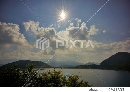 沼原ダムの湖面と太陽 109818354