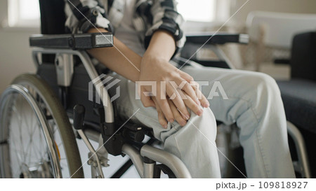 Boy feeling pain in knees, sitting in wheelchair, rehabilitation after injury Boy feeling pain in knees, sitting in wheelchair, rehabilitation after injury 109818927