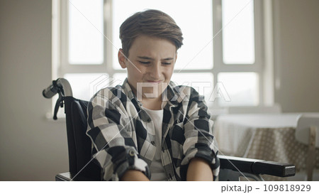 Teenager in wheelchair feeling acute knee pain, rehabilitation after injury, disability 109818929