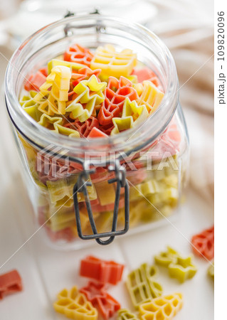 Uncooked raw pasta. Various Christmas shapes. Pasta in jar on white table. Uncooked raw pasta. Various Christmas shapes. Pasta in jar on white table. 109820096