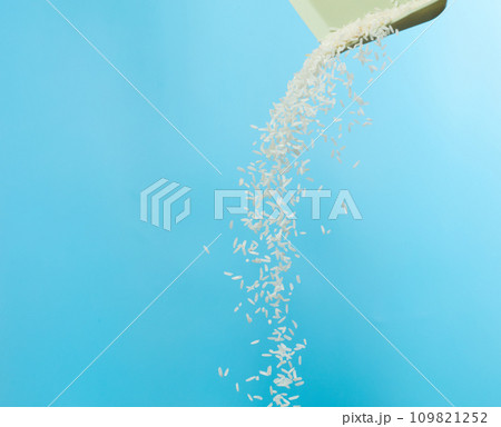 White Rice grain fly in mid air. Ready Rice falling scatter, explosion float in shape form line group. Blue sky background isolated freeze motion 109821252