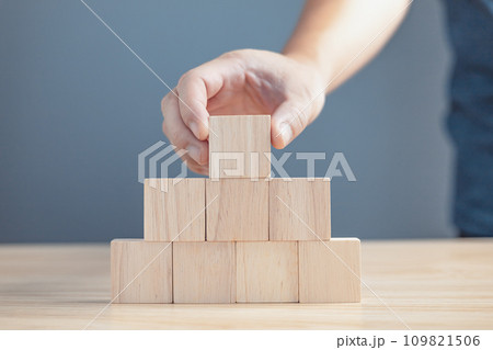 hand of a businessman stacking wood empty eight blocks with copy space for text or symbols, development concept for growth success process. hand of a businessman stacking wood empty eight blocks with copy space for text or symbols, development concept for growth success process. 109821506