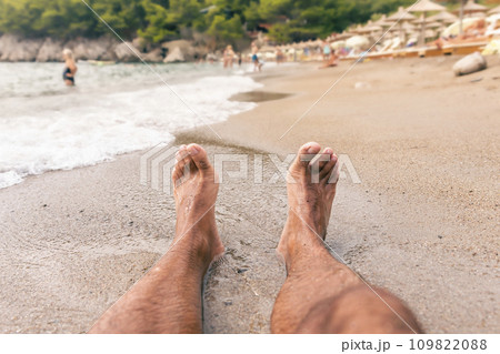 Mans feet on the beach. Relaxing and enjoying the sand Mans feet on the beach. Relaxing and enjoying the sand 109822088