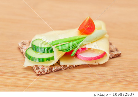 Whole Grain Crispbread with Cheese, Fresh Cucumber, Radish, Tomato and Green Onions 109822937