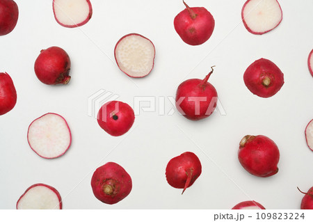 Whole and sliced fresh radishes on white background. Creative pattern. 109823224