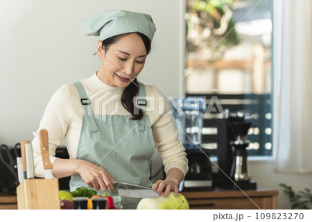 包丁で白菜を切るエプロン姿の女性 包丁で白菜を切るエプロン姿の女性 109823270