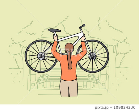 Woman hangs bicycle on pickup truck for trip to nature and active recreation during summer holidays 109824230