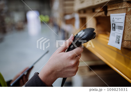 Scanner, scanning the barcodes on products in warehouse. Warehouse manager using warehouse scanning system. Scanner, scanning the barcodes on products in warehouse. Warehouse manager using warehouse scanning system. 109825031