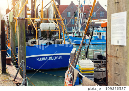 Traditional old german fishing cutter boats moored Neuharlingersiel harbor Wadden sea East Frisia Northern Germany. Commercial fish crab shrimp trawler beam trawl nets North Sea small port city 109826587